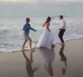 Ξεκαρδιστικό βίντεο: Η νύφη φωτογραφιζόταν αλλά τα κύματα την έριξαν μέσα & να τα γέλια του γαμπρού! 