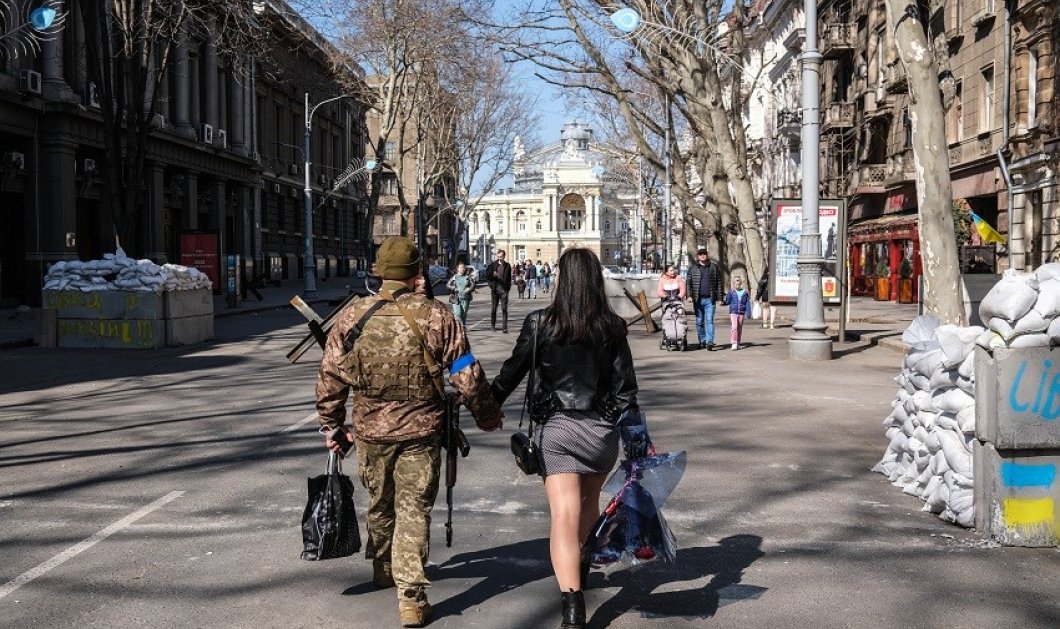 Φωτό ημέρας ο Ουκρανός στρατιώτης και η καλή του - περπατούν χέρι, χέρι δίπλα σε οδοφράγματα - κλικ από Sedat Suna/EPA