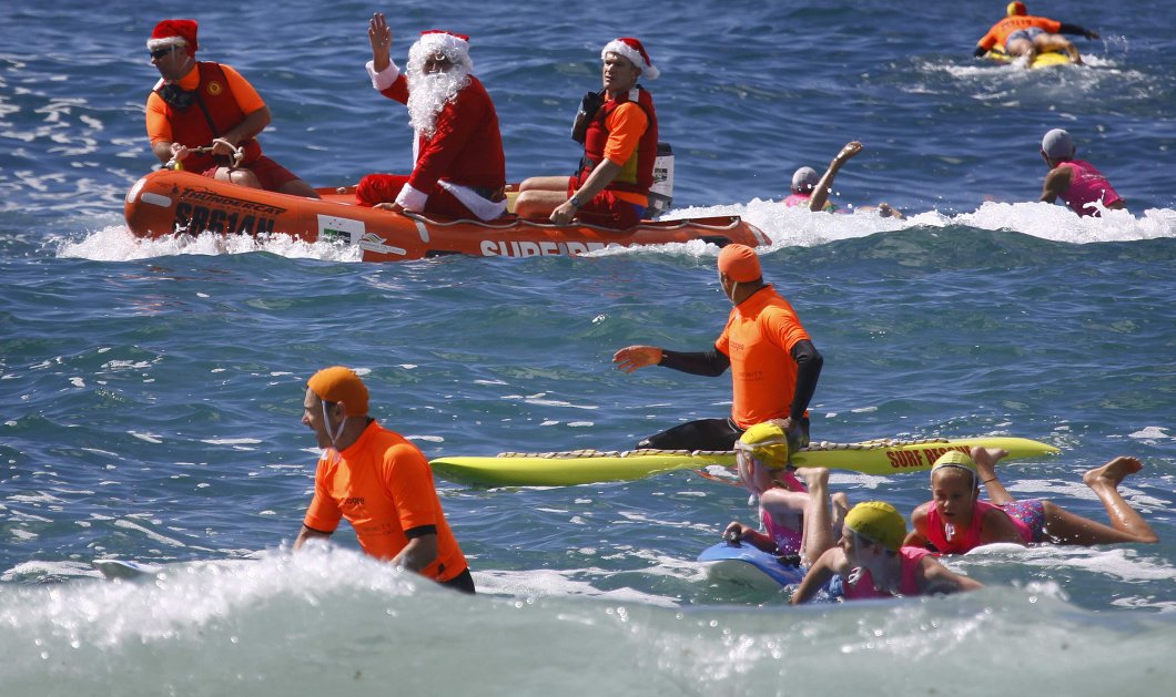 15/12/2014 - Καλοκαιρινά Χριστούγεννα στην Αυστραλία - Αϊ Βασίληδες με βάρκες βγαίνουν στην στεριά! Reuters