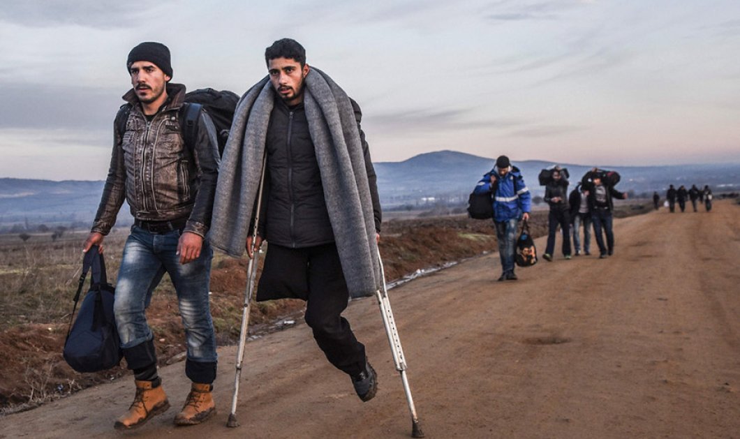 Ένας πρόσφυγας με ένα πόδι και πατερίτσες, βαδίζει αργά προς την ελπίδα στα σύνορα Σκοπίων–Σερβίας, κοντά στο χωριό Μιράτοβατς