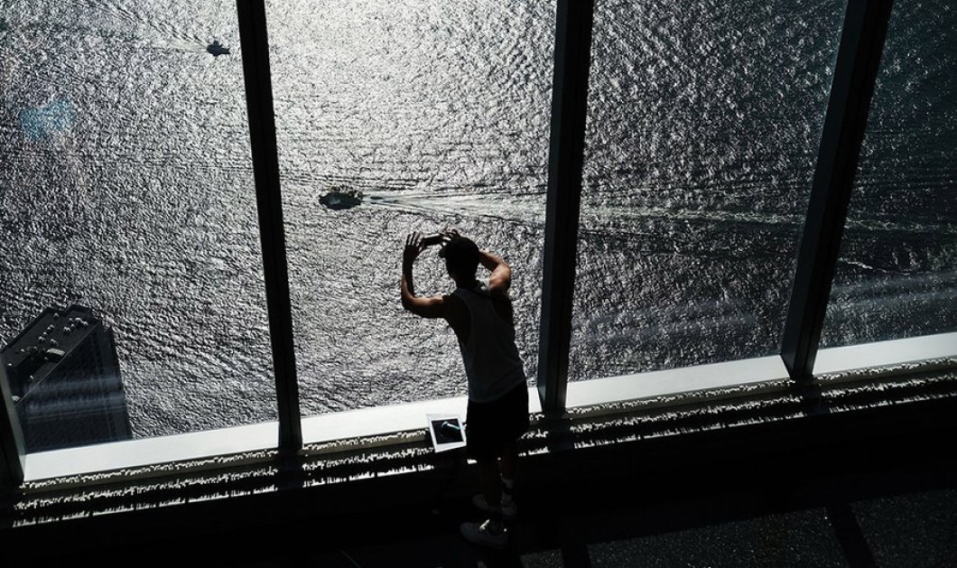 Από τον 104ο όροφο καινούργιου ουρανοξύστη ύψους 541 μέτρων, επισκέπτης φωτογραφίζει τα πλεούμενα του ποταμού Χάντσον - REUTERS