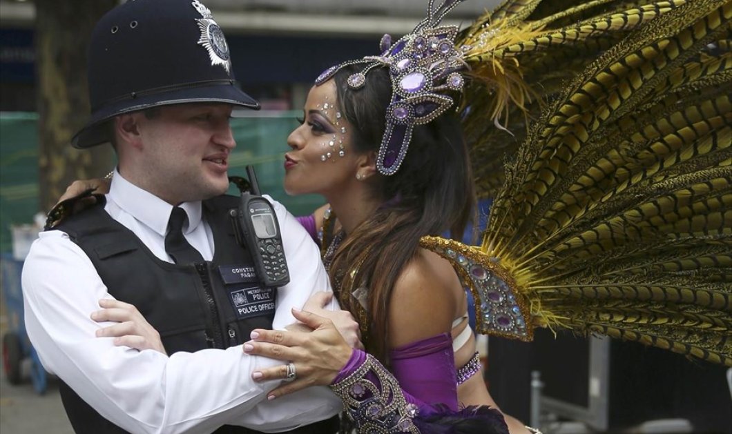 Χορεύτρια πλησιάζει έναν αστυνομικό, κατά τη διάρκεια του καρναβαλιού του Νότινγκ Χιλ, στο Λονδίνο - Picture: REUTERS / NEIL HALL 