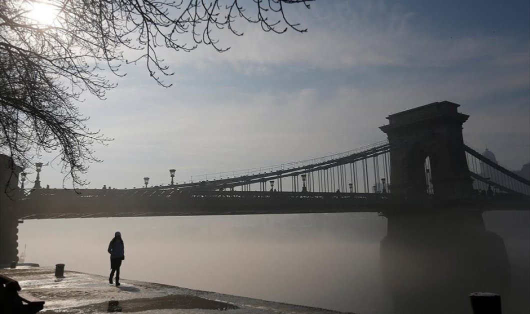 Πρωινό με ομίχλη στη Βουδαπέστη & γυναίκα περπατά πλάι στον ποταμό Δούναβη - Φωτογραφία: REUTERS / LASZLO BALOGH