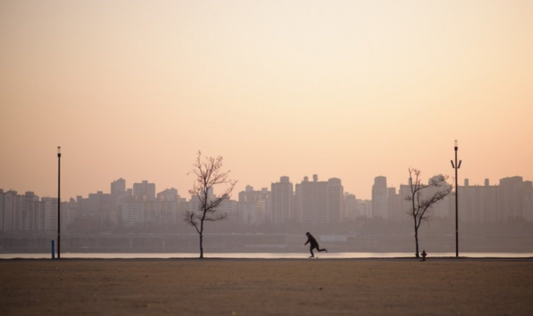 18/01/2015 - Ένας Νοτιοκορεάτης βολτάρει με το skateboard του κατά μήκος ενός ποταμού λίγο πριν την αυγή - Φωτό: Ed Jones/AFP/Getty Images