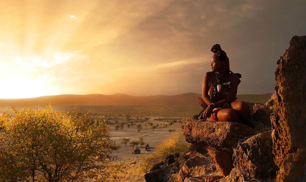 Το χρυσό φως του ηλίου λούζει μια όμορφη γυναίκα στη Ναμίμπια με φόντο ένα εκπληκτικό τοπίο - Photograph by Bjorn Persson