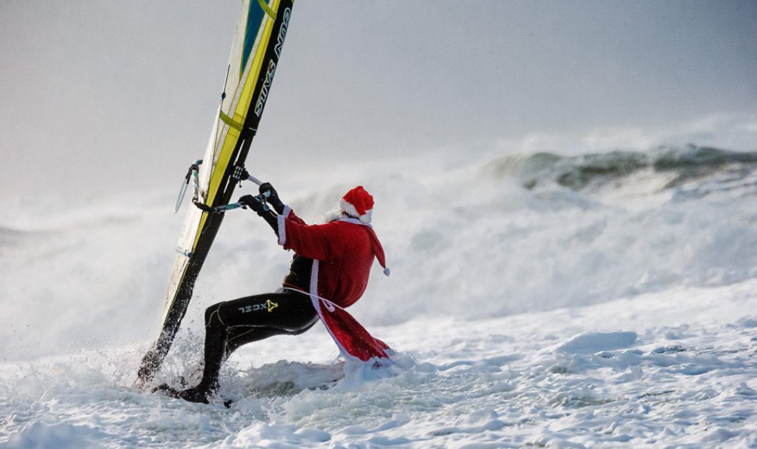    Σέρφερ στην Γερμανία ντυμένος Άγιος Βασίλης δαμάζει τα κύματα σε χριστουγεννιάτικο mood - EPA/MARKUS SCHOLZ
