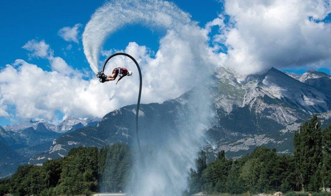 Ένας άνδρας κάνει ακροβατικά με flyboard σε μια μικρή τεχνητή λίμνη της Σιόν, στην Ελβετία- EPA / OLIVIER MAIRE