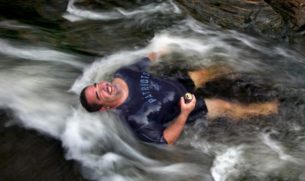 20/8/2015 - Πως νικάς τον καύσωνα; Αν είσαι στο Maine βουτάς στα νερά με μια μπύρα στο χέρι!  Picture: AP Photo/Robert F. Bukaty