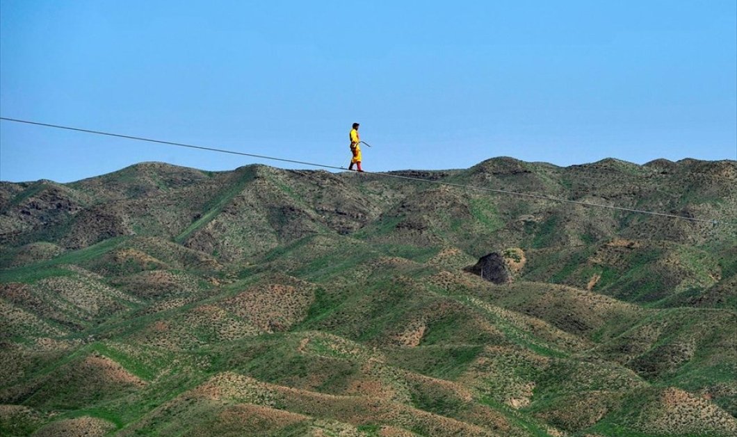 Ένας άντρας ακροβατεί σε τεντωμένο σχοινί, στην Qingtongxia, στην αυτόνομη περιφέρεια Νινγζιά, στην Κίνα - REUTERS / CHINA STRINGER NETWORK