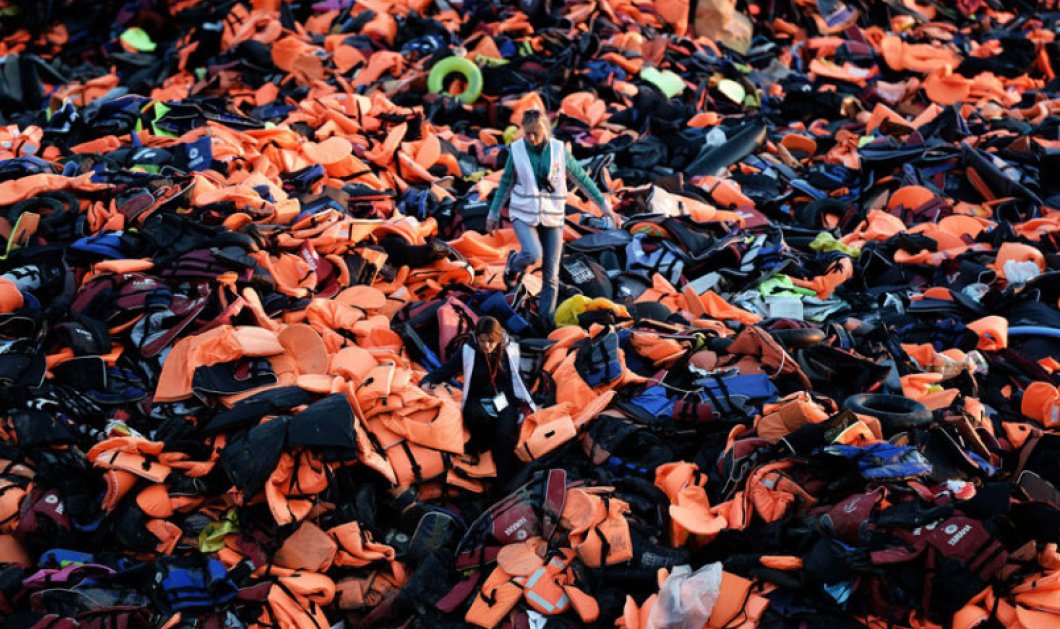 Φώτο ημέρας από την Λέσβο κάνει τον γύρο του κόσμου, εθελόντριες περπατούν ανάμεσα σε χιλιάδες σωσίβια γιλέκα - Picture: Getty Images