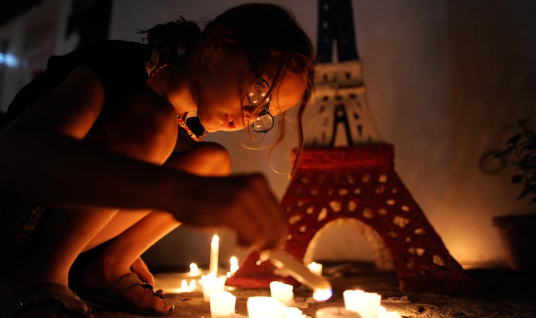  Ένα κοριτσάκι ανάβει κεριά στη μνήμη των νεκρών του Παρισιού - Picture: Dondi Tawatao/Getty Images
