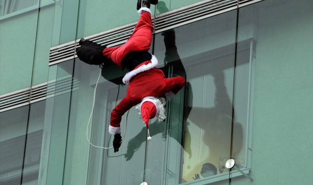 17/12/2014 - «Ριψοκίνδυνος» Άγιος Βασίλης επισκέπτεται παιδιατρική κλινική στη Λιουμπλιάνα της Σλοβενίας και προσφέρει χαμόγελα στα παιδιά! REUTERS / SRDJAN ZIVULOVIC