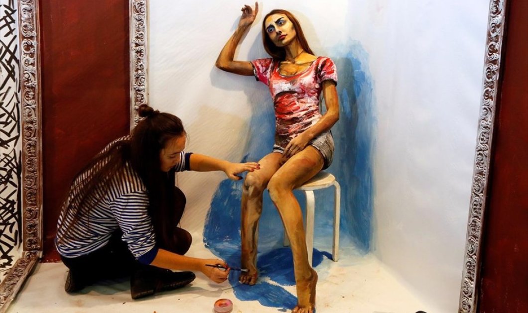Η Ρωσίδα  Μαρία Γκασάνοβα ζωγραφίζει πάνω στο μοντέλο Ίνα Μαγκομέντοβα, για το έργο της «Ο ζωντανός πίνακας», στο ετήσιο φεστιβάλ τέχνης στη Σιβηρία - REUTERS / ILYA NAYMUSHIN