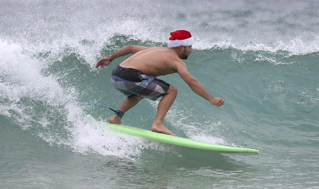 25/12/2014 Ο Ελβετός τουρίστας Philip Conway φοράει ένα καπέλο του Άγιου Βασίλη καθώς κάνει σερφ γιορτάζοντας την ημέρα των Χριστουγέννων στη παραλία Bondi Beach στο Σίδνεϊ Picture: AP Photo/Rick Rycroft