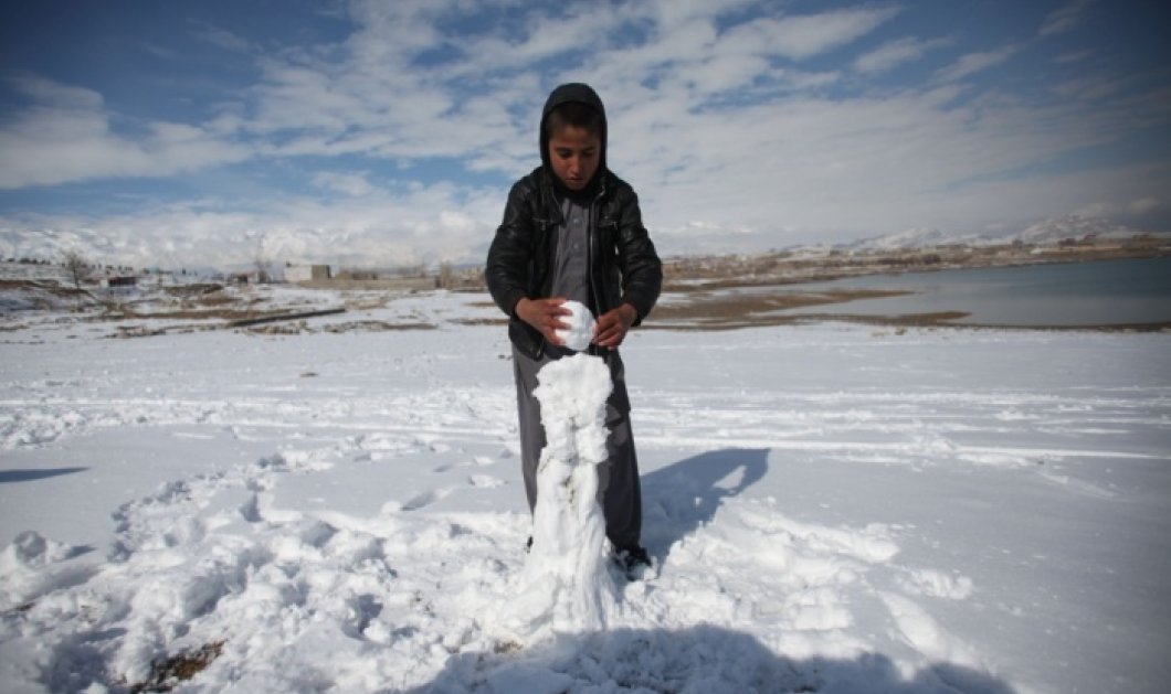 22/01/15 - Ένα αγοράκι από το Αφγανιστάν φτιάχνει με ευλάβεια και μεγάλη προσοχή τον χιονάνθρωπό του - Φωτό: Αhmad Massoud/Xinhua Press/Corbis