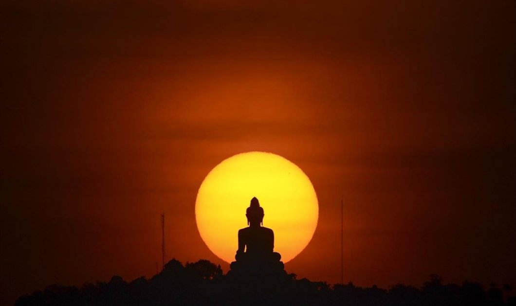 Ο ήλιος δύει πίσω από άγαλμα του Βούδα στο Πουκέτ - Picture: REUTERS / ATHIT PERAWONGMETHA