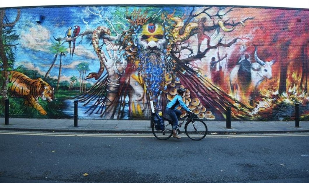Η κοπέλα κάνει ποδήλατο στους δρόμους του Λονδίνου - Φωτογραφία: EPA / FACUNDO ARRIZABALAGA