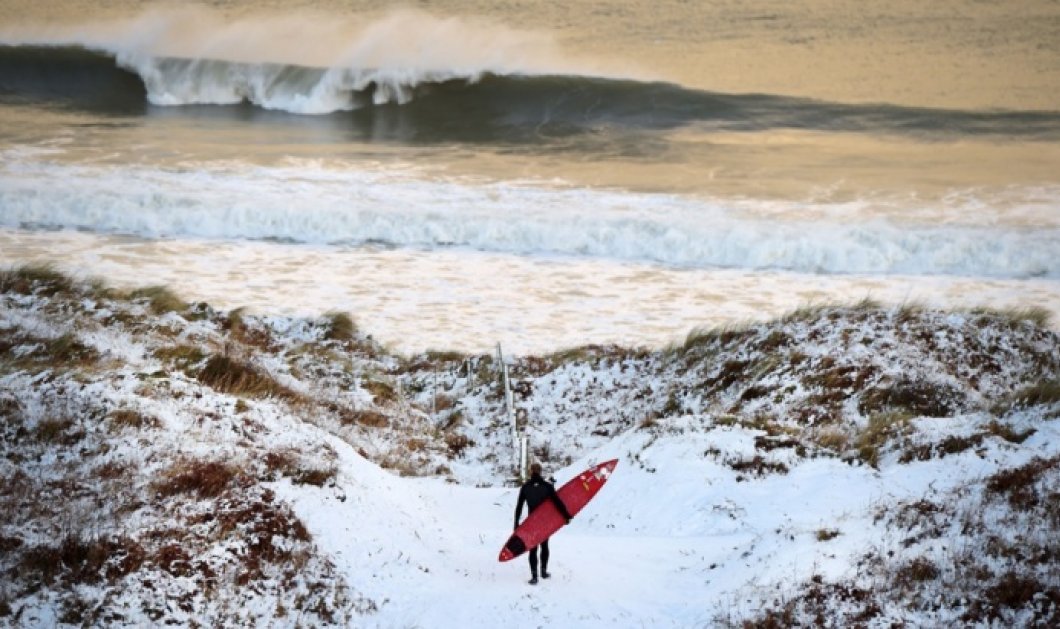 14/1/15 - Κάθε μέρα είναι καλή για σερφ! Αψηφώντας το πολικό ψύχος της Β. Ιρλανδίας, αυτός ο σέρφερ ετοιμάζεται να δαμάσει τα κύματα! Φώτο: Charles McQuillan/Getty Images