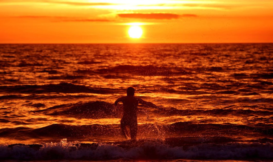 Εκπληκτικό στιγμιότυπο: Άντρας τρέχει προς την Βαλτική θάλασσα την ώρα που ο ήλιος δύει στην Γερμανία - Picture: EPA 