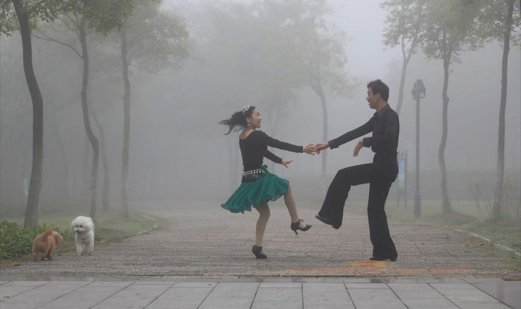 Ένα ζευγάρι χορεύει στην ομίχλη, στο Χουαϊάν της Κίνας - Φωτογραφία: REUTERS / CHINA STRINGER NETWORK